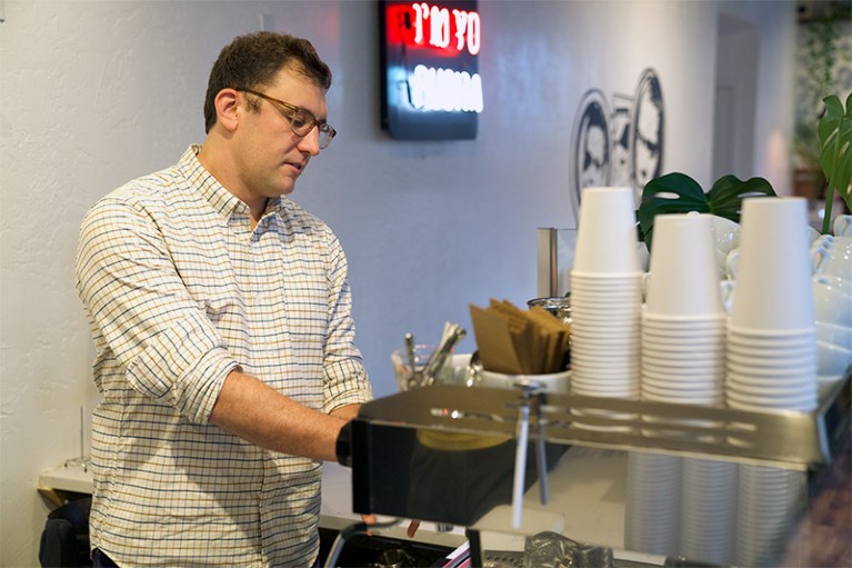 Christopher H. Hendon concentrating pouring a coffee from a coffee machine