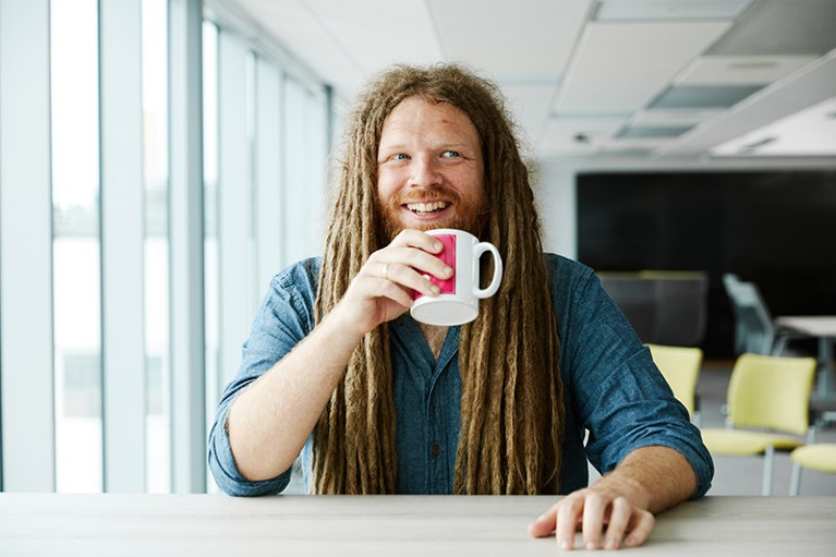 Bearded and dreadlocked Jamie Foster sat enjoying a mup of coffee