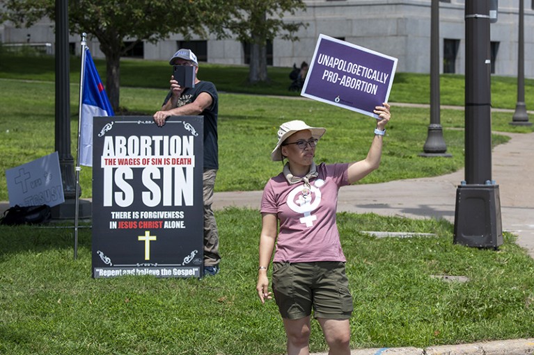Anti and pro demonstrators hold up signs at a march in support of legal national abortion rights, St. Paul, Minnesota, US, 2022.