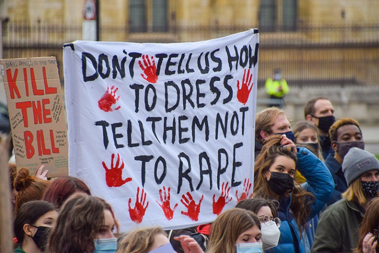Young female protesters marching in London with placards calling for to end male violence against women