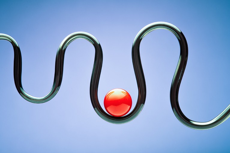 One red ball in valley of curving black tube, gradated blue background