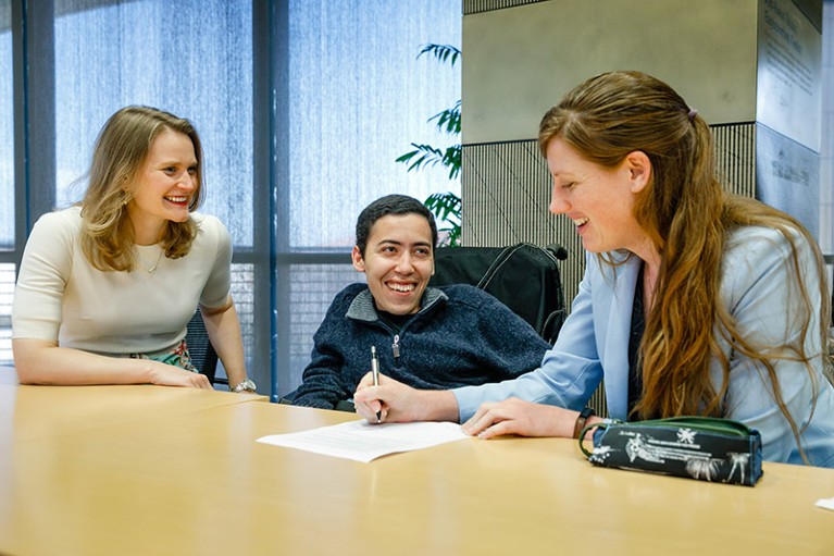 Megan Kenna sat in discussion at a table with two of the Schmidt Science Fellows