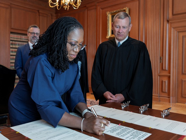 Justice Ketanji Brown Jackson signs her oaths of office in the Justices' Conference Room at the Supreme Court building.