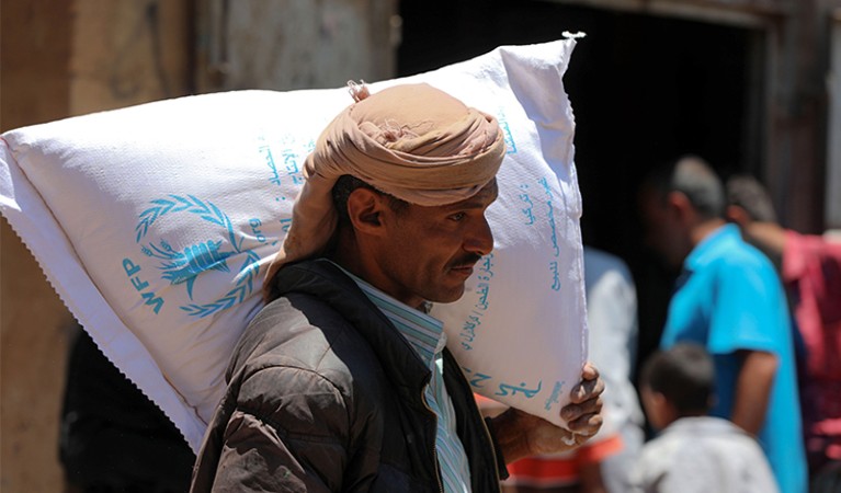 A Yemeni man receives humanitarian aid, donated by the World Food Programme (WFP), in the country's third city of Taez. Yemen.