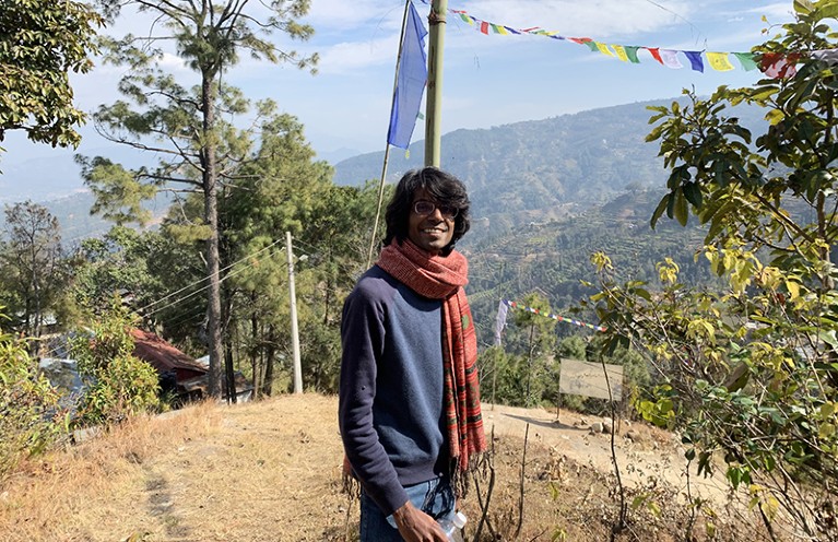 Emmanuel Raju stands outside, surrounded by trees, in Nepal