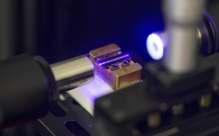 Close-up of a purple laser testing the optical waveguide of a chip for quantum computing