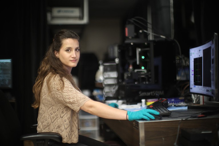 Wendy Wenderski working at a computer in a dark lab at Stanford University