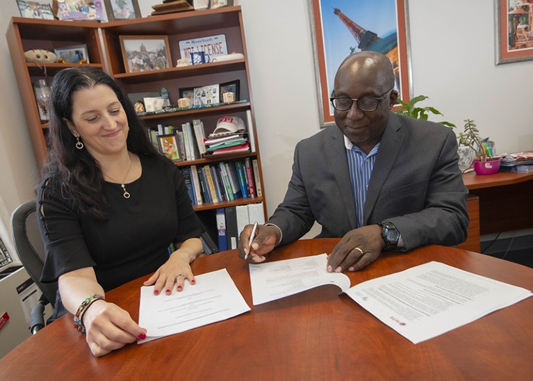 A man and a women review a paper together.