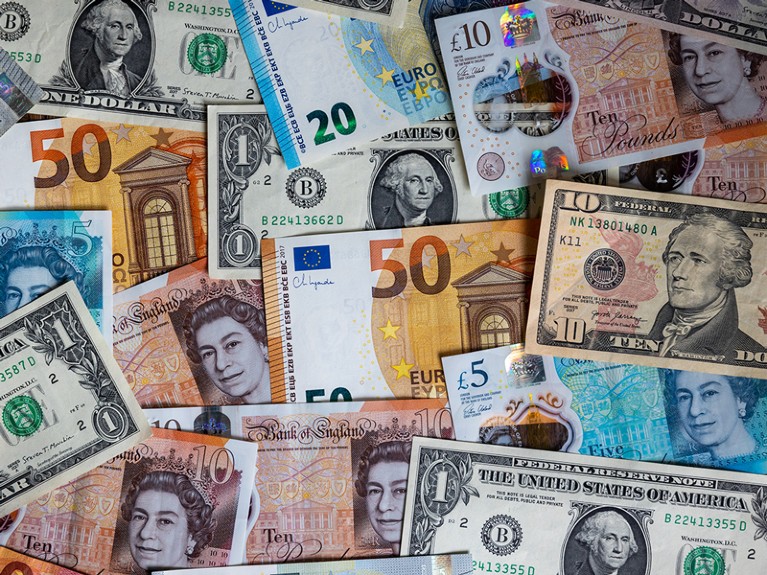 U.S. dollar bills, British GDP and Euro currency bank notes.