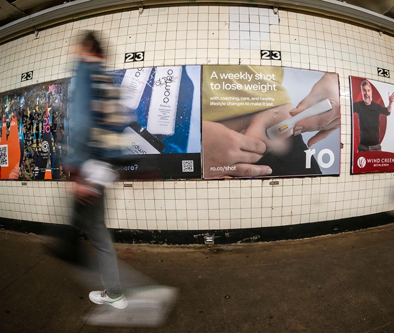 A person passes advertising for Wegovy (semaglutide) weight loss injections in the New York subway.
