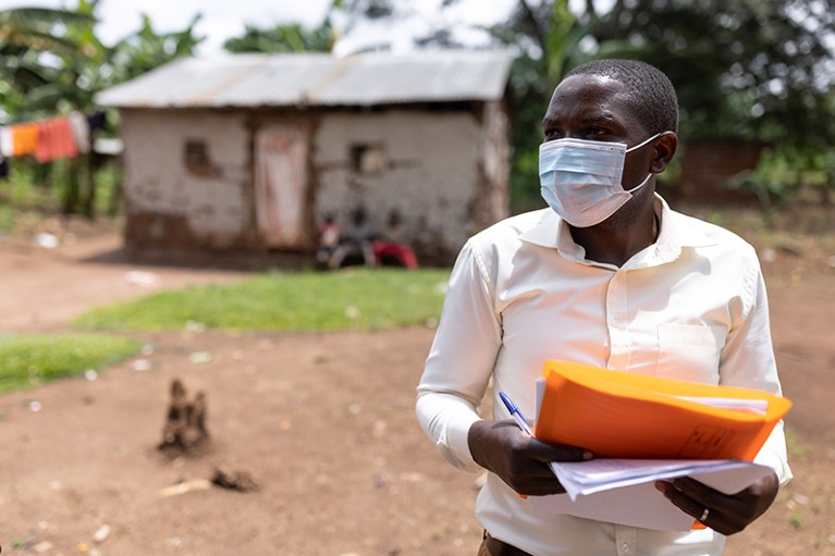 A contact tracer wearing a face mask attempts to find recent contacts of people with Ebola.