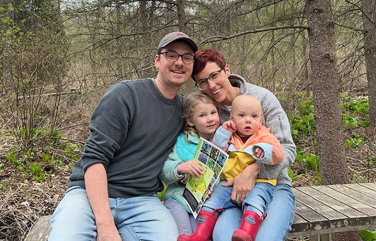 Amanda Gorton with her husband and two young children sat on a woodland boardwalk