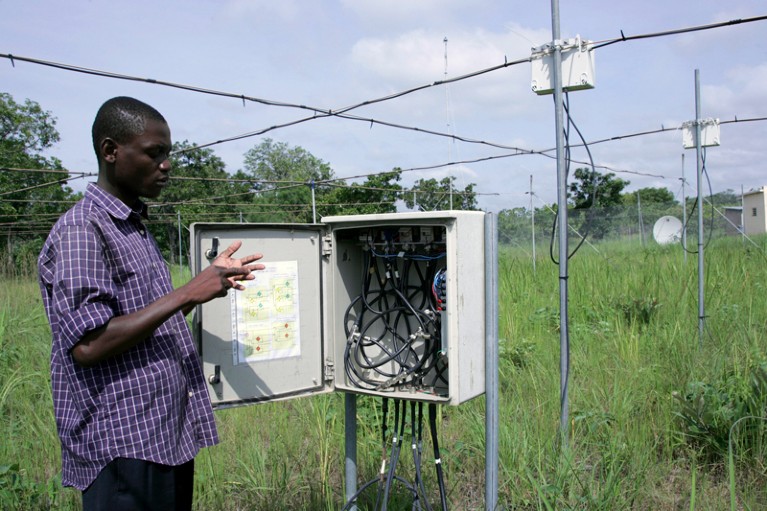 A meteorologist inspects the electronics for the antennas for a weather radar station in Nangatchori, Benin