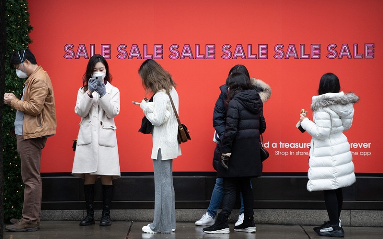 Shoppers, some wearing masks to combat the spread of Covid-19, queue to enter Selfridges store, London.