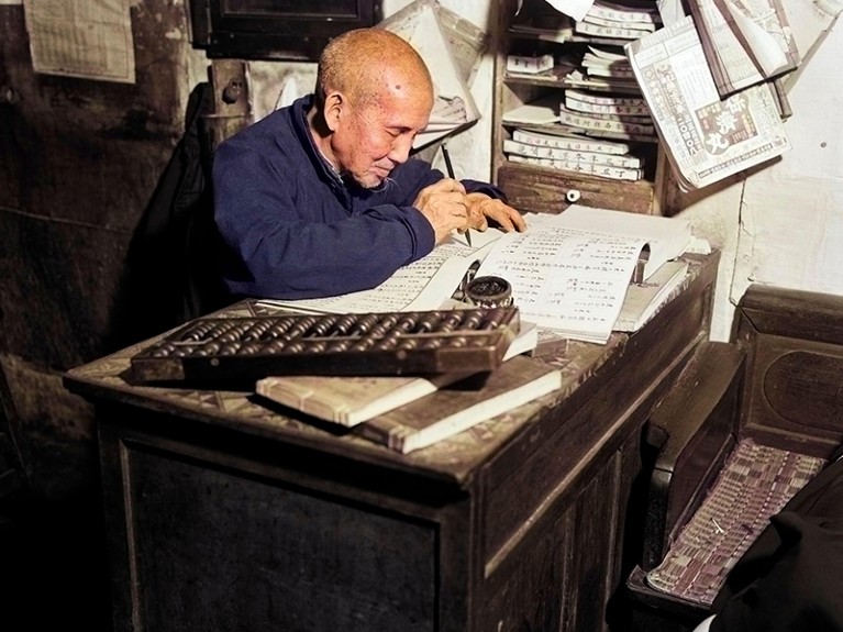 Chinese man writing ledger using abacus bookkeeper accountant worker accounting office scribe hong kong china, 1920-30s.