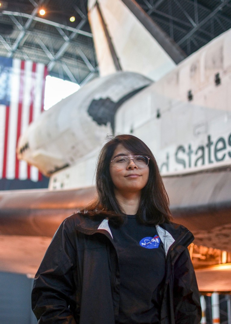 Portrait of Nicole McGaa standing in front of the Space Shuttle Discovery