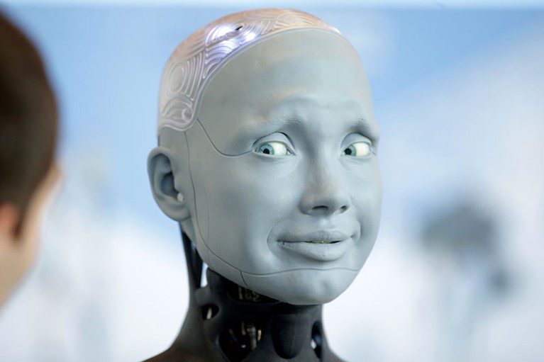Un robot a forma umana guarda lateralmente una persona.