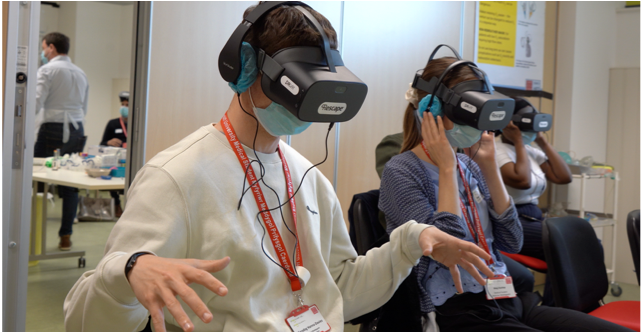 Three seated students are wearing VR glasses.