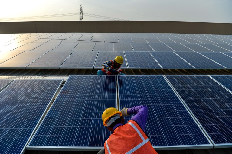 Indian labourers install solar panels