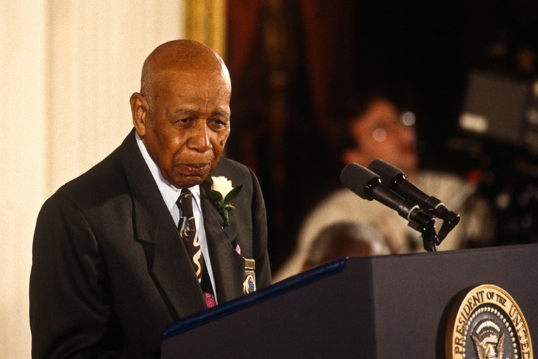 An elderly Herman Shaw, a survivor of the Tuskegee Syphilis Study, stands at a White House podium.