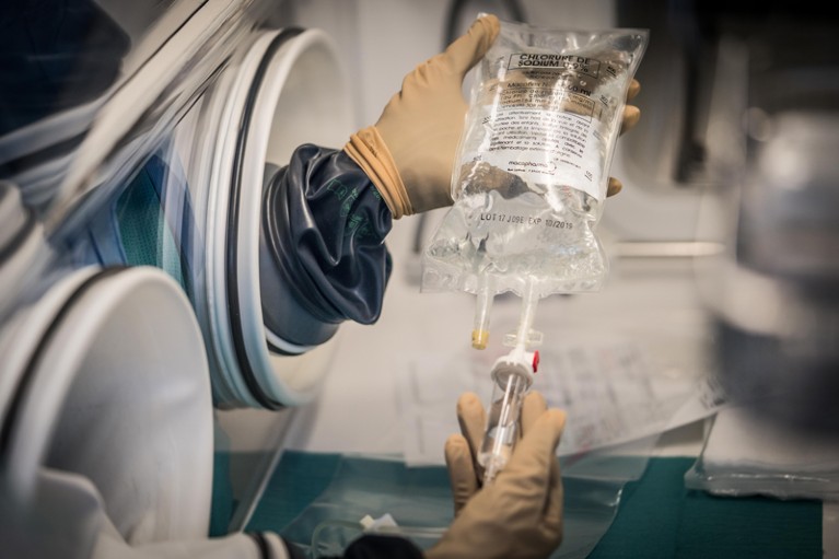 Close-up of a gloved hand handling a clear immunotherapy treatment bag