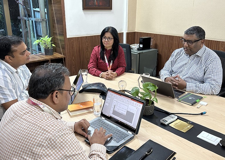 Prabuddha Kundu along with his senior colleagues, discussing the weekly key updates and strategic review, at a conference table.