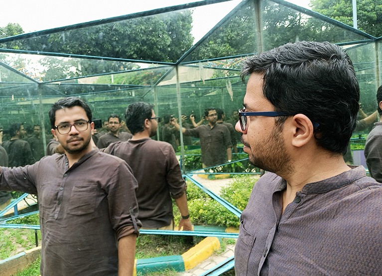 Portrait of Satyaprakash Pandey in a mirrored maze with plants outside it.