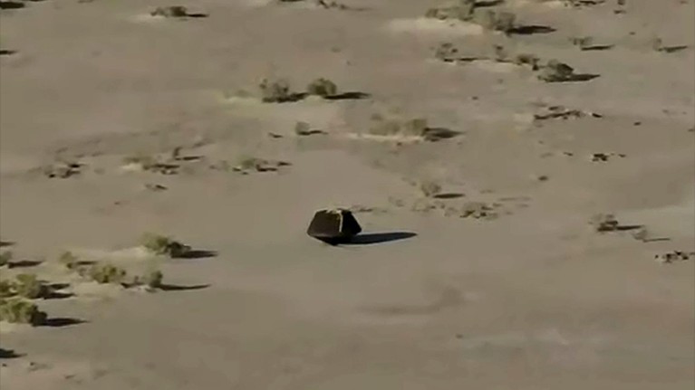 An image taken from NASA TV shows the capsule released by the Osiris-Rex spacecraft lying on the surface after landing to Earth.