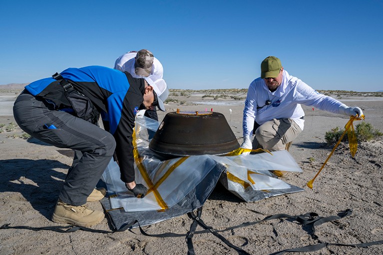 Lockheed Martin Recovery Specialists prepare the sample return capsule from NASA's OSIRIS-REx mission for transport.