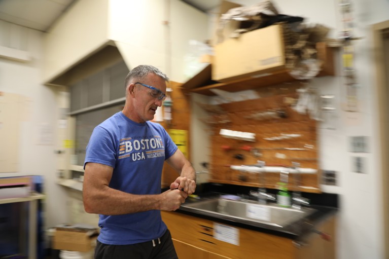 Christopher Reddy wears protective eyewear while walking in his laboratory