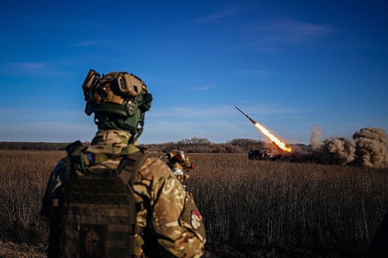 A Ukrainian soldier watches a self-propelled rocket launcher firing towards Russian positions on the front line in 2022.