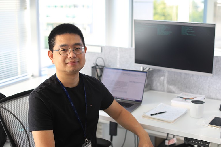Portrait of Tommy Tang in front of his desk and computer.