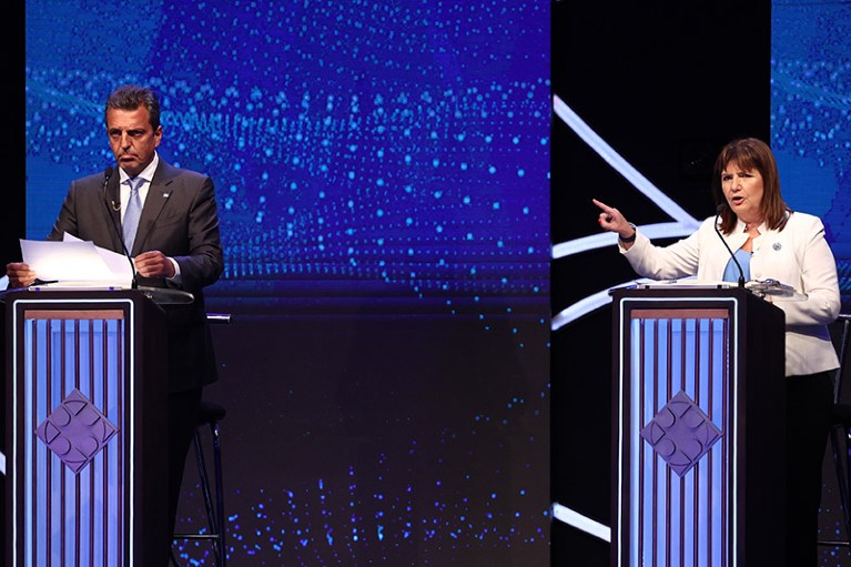 Presidential candidate Sergio Massa speaks and Patricia Bullrich gestures during a televised debate.