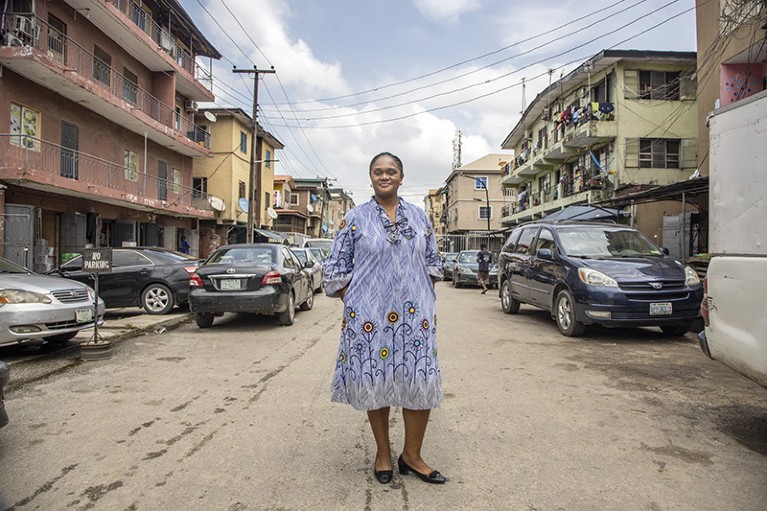 Person standing in the middle of a street. Vehicles and buildings on either side