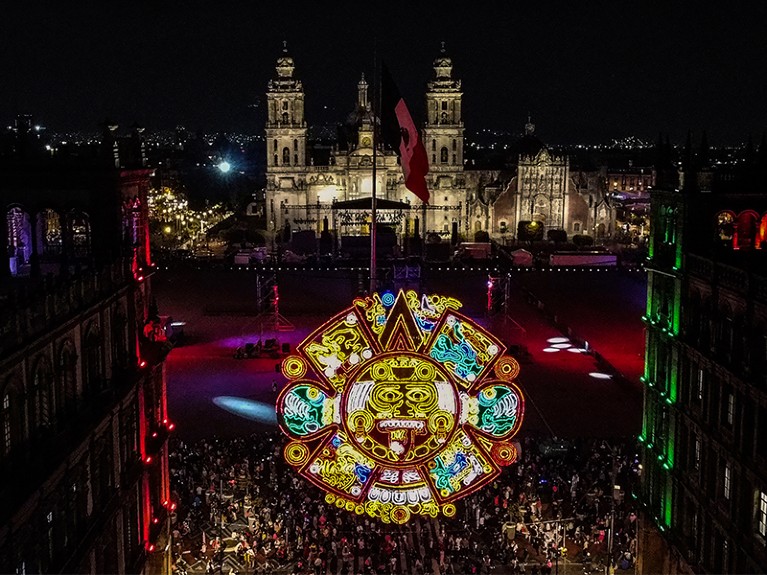 Aerial view of a giant illuminated decoration of the Aztec sun stone and the Zocalo main square, Mexico City.