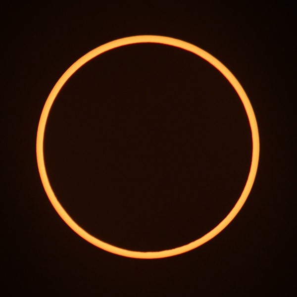 Orange ring of an annular solar eclipse on an otherwise black background