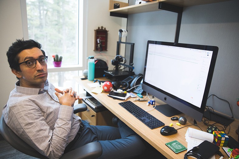 A portrait of Soroush Vosoughi sitting in front of a computer.