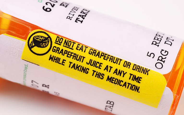 Close-up of a warning label about consuming grapefruit on a bottle of prescription medication.