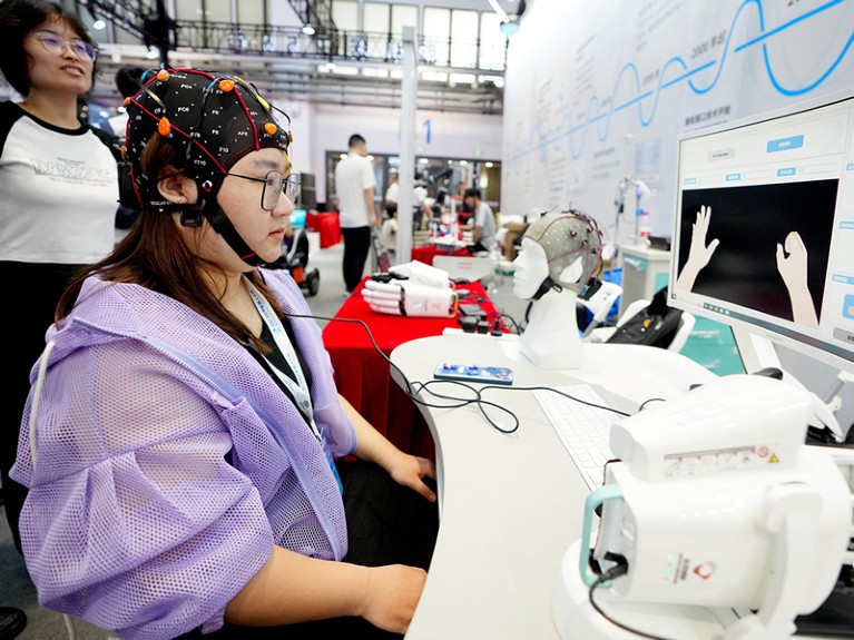 A staff member demonstrates a brain-computer interface at the World Robot Conference 2023 in Beijing.