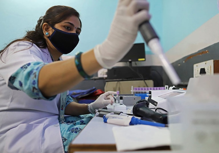 A lab technician prepares a sample for a demonstration of smart COVID-19 testing in New Delhi.