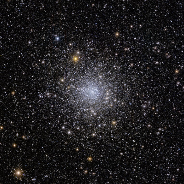 Lots of bright white stars clustered together at the centre of a less dense star field.