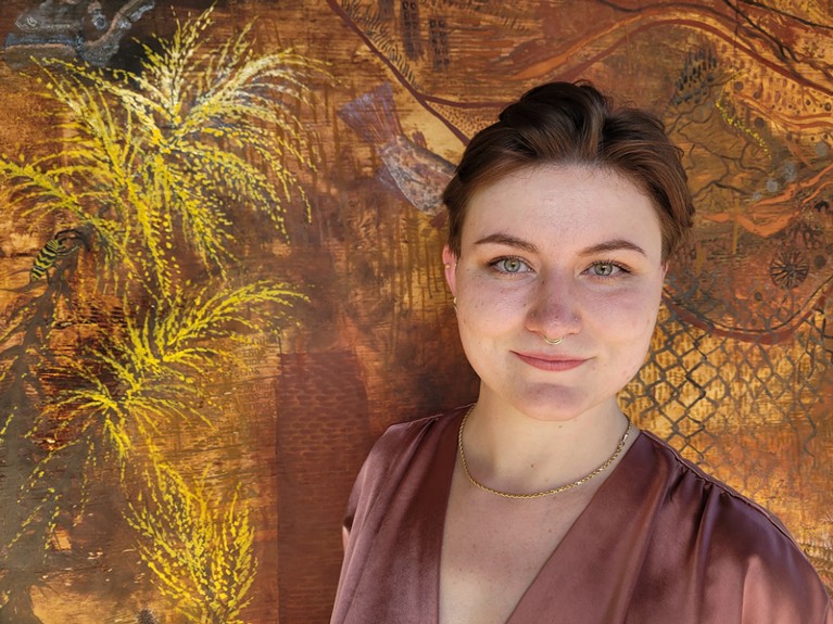 Sierra Weir in front of her natural pigment painting Naturalize.