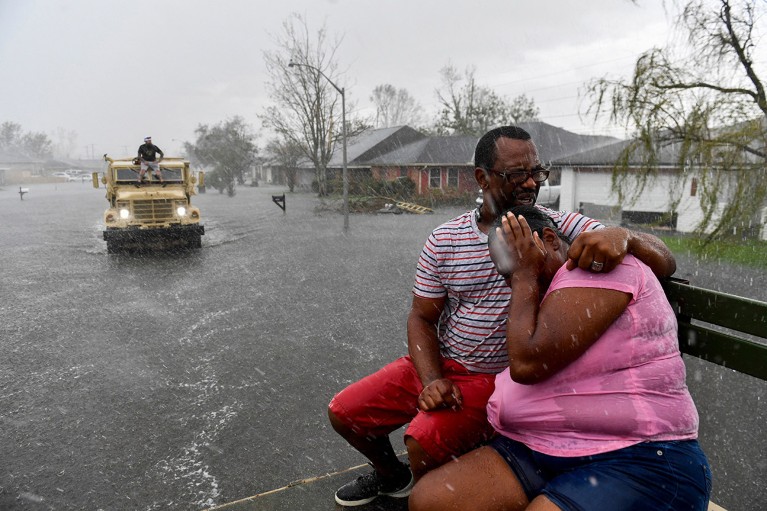 People react as a sudden rain shower soaks them while being evacuated flooded homes in Louisiana.