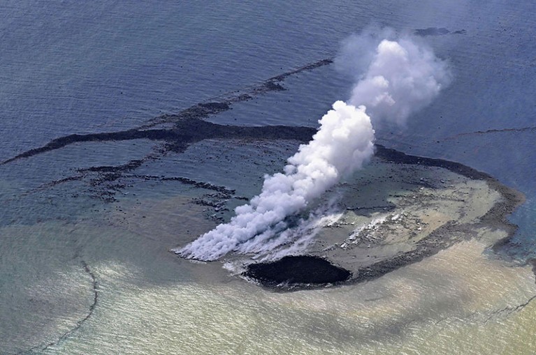 Steam rises from the sea off southern Tokyo.  A new island with a diameter of 100 meters formed by the erupted rock can be seen near the steam.