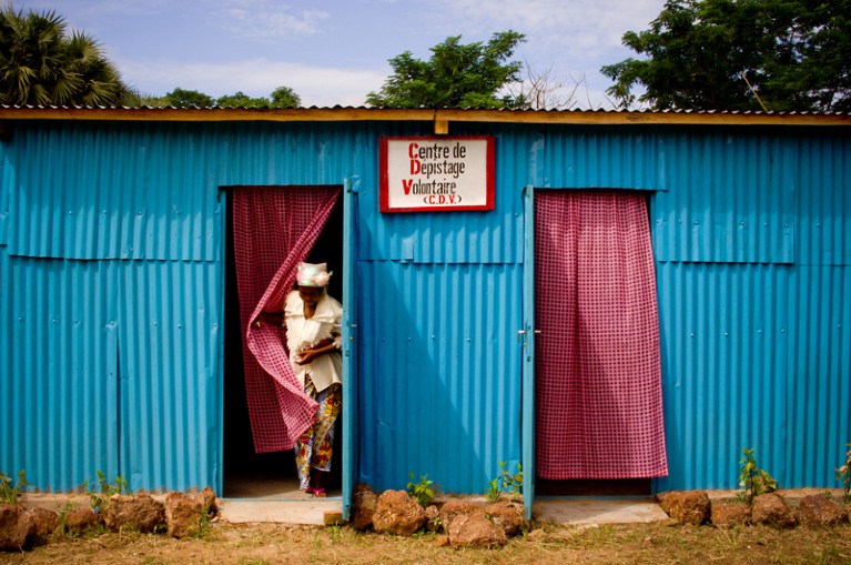 A woman exits a blue HIV/AIDS centre building
