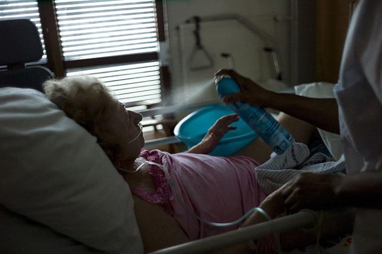 A nurse sprays water to cool off an old woman at the geriatric hospital in Paris, France.