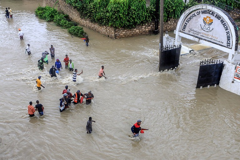 Pedestrians try to pass a flooded street following heavy rains in Mombasa, Kenya.
