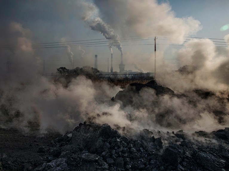 Steam and smoke from waste coal and stone rises after being dumped next to an unauthorized steel factory on November 3, 2016 in Inner Mongolia, China.