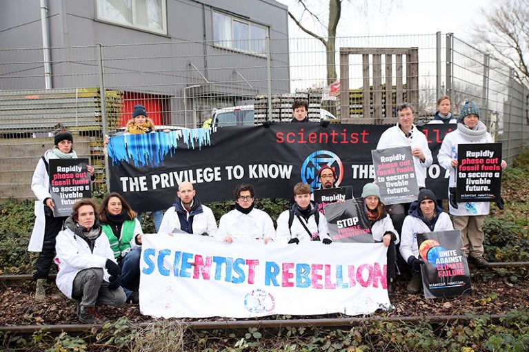 Scientists blocking a coal track in Amsterdam, calling for a rapid phase out of fossil fuels.