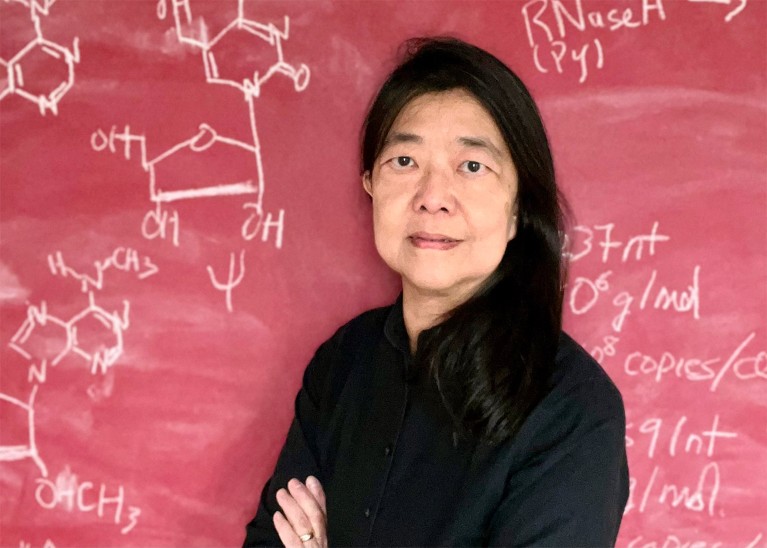 Dr Vivian G. Cheung with a chalkboard behind her and RNA molecular structures shown